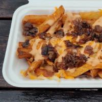 All American Fries · A mound of fries topped with house-made 1000 island, grilled onions, and smothered in a ched...