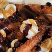 Sweet Potato S'Mores · Cinnamon sugar tossed sweet potato fries topped with roasted marshmallows and drizzled with ...