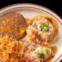Huevos Rancheros · 2 crispy corn tortillas topped with sunny side up eggs and red chunky tomato sauce and parme...