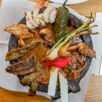 Molcajete Trio · Grilled shrimp, chicken and beef served in molcajete bowl with chorizo sauce. Topped with gr...