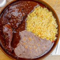 Mole Con Pollo · Poblano-style chicken smothered in dark mole sauce. Served two sides.