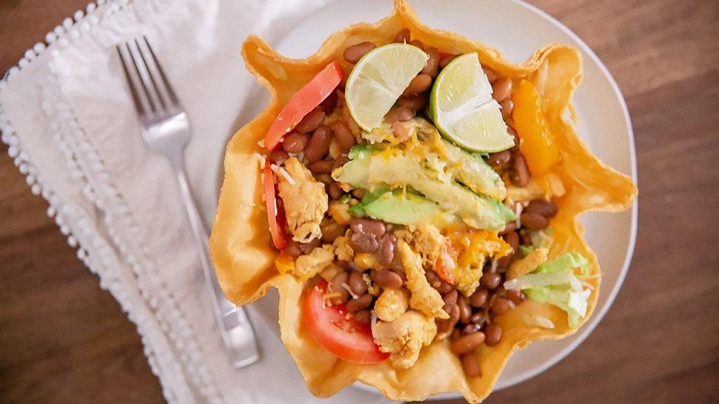 Taco Salad · Tortilla bowl filled with lettuce, diced tomato, pinto beans, avocado, Mexican cheese, and sour cream. Topped with grilled chicken or carne asada steak.