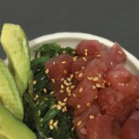 Tuna Poke · Diced up tuna is laid on top of a bed of seaweed salad. There is a side of avocado inside th...