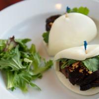 Pork Belly Buns · Braised pork belly served in steamed buns with pickled greens, crushed peanuts, and cilantro.