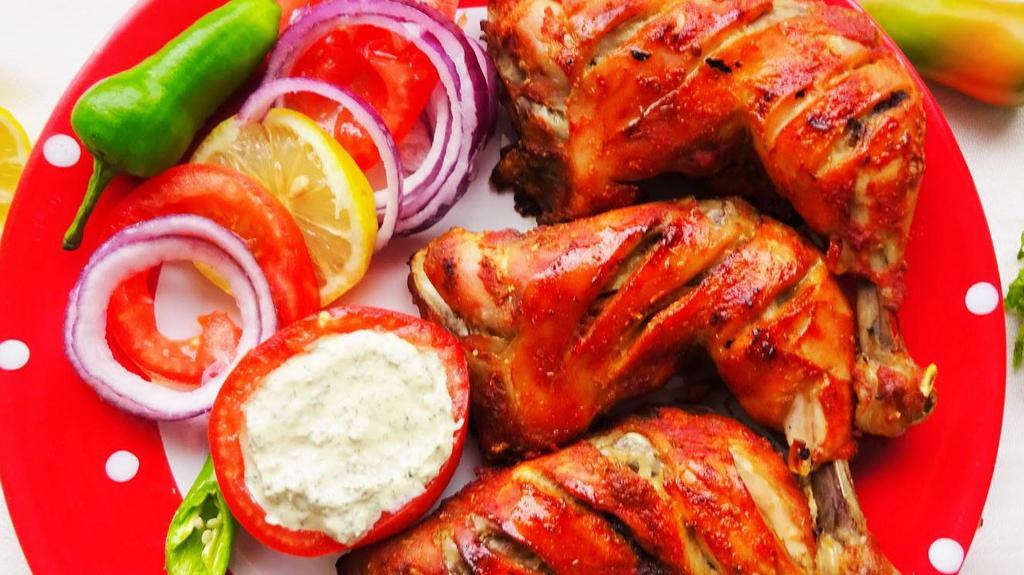 Chicken Tandoori · Chicken leg and thigh pieces are marinated overnight in yogurt with herbs, spices and cooked on skewers in tandoor (clay oven).