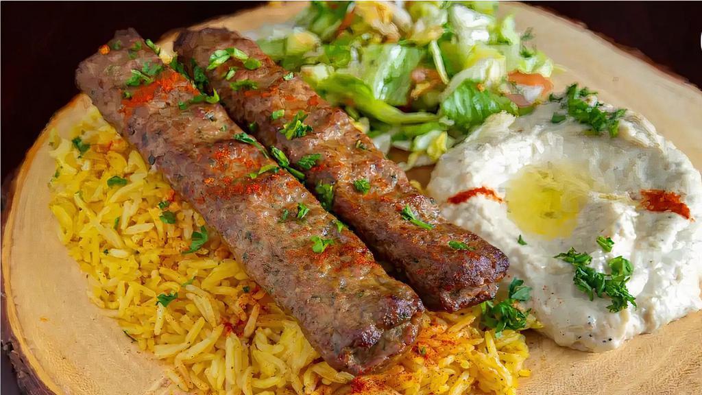 Kufta Kabab Plate · Grilled Kafta Kabab  placed on a bed of basmati rice and our homemade Mediterranean TZATZIKI SAUCE Homemade Hummus sauce and green salad served with pita bread and homemade hot sauce in option