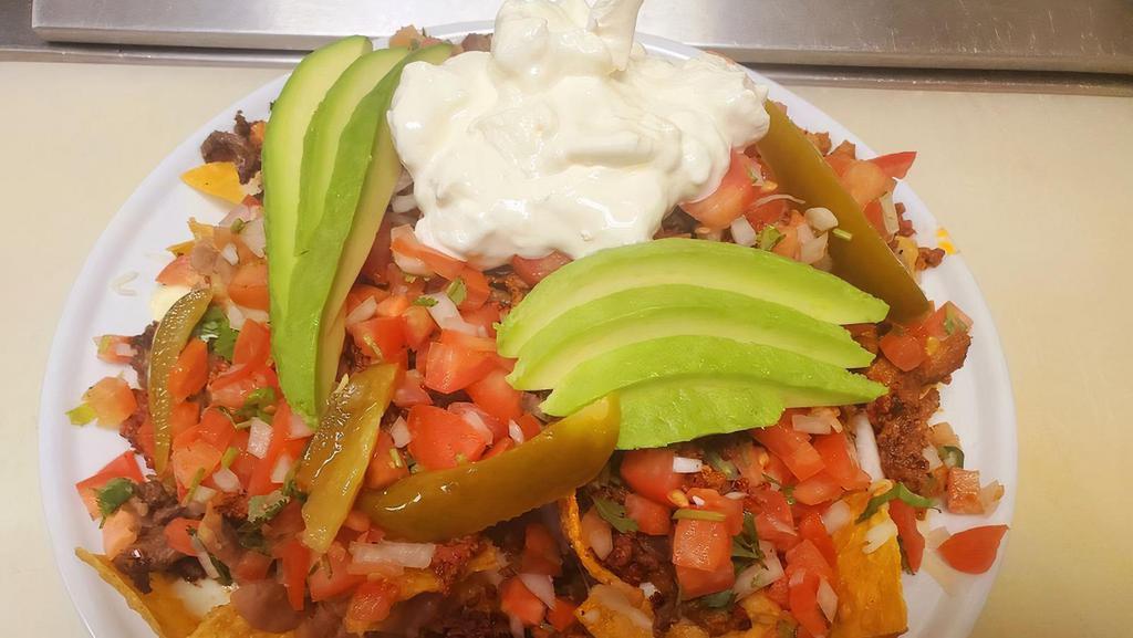 Nachos Nacho Mix · House made tortilla chips covered in your choice of meat &monterey jack cheese, beans pico de gallo jalapenosand sour cream- guacamole