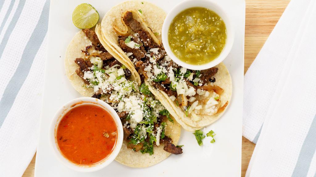 Tacos (Street Tacos) (4) · Corn tortilla tacos served with your choice of any meat, onions, and cilantro, tomatoes, cotija cheese, caramelized onions, limes, red and green salsa.