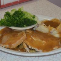 Turkey Dinner · Our oven roasted turkey, thick cut and served on a bed of cornbread stuffing. Topped with ho...