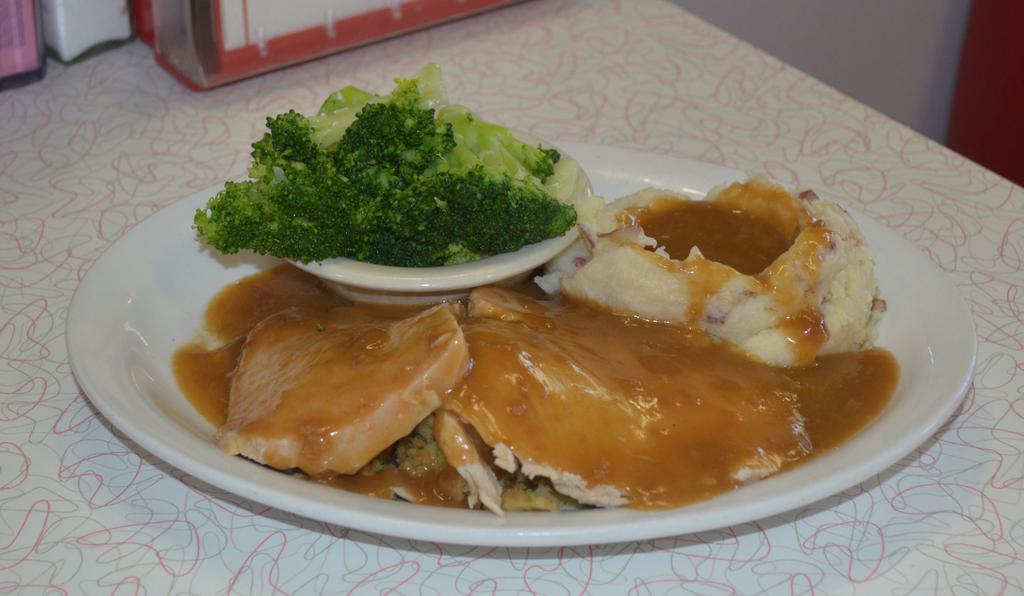 Turkey Dinner · Our oven roasted turkey, thick cut and served on a bed of cornbread stuffing. Topped with homemade turkey gravy. Served with the vegetable of the day and your choice of a side.