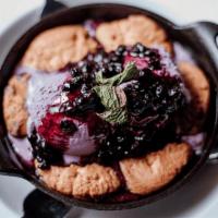Doc Holliday · White chocolate macadamia nut cookies served in a piping hot skillet with huckleberry ice cr...