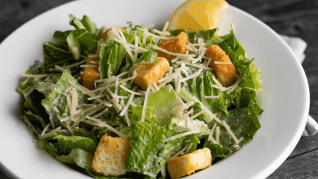 Caesar · Romaine, shredded parmesan & seasoned croutons tossed in Caesar dressing. Anchovies by request.
