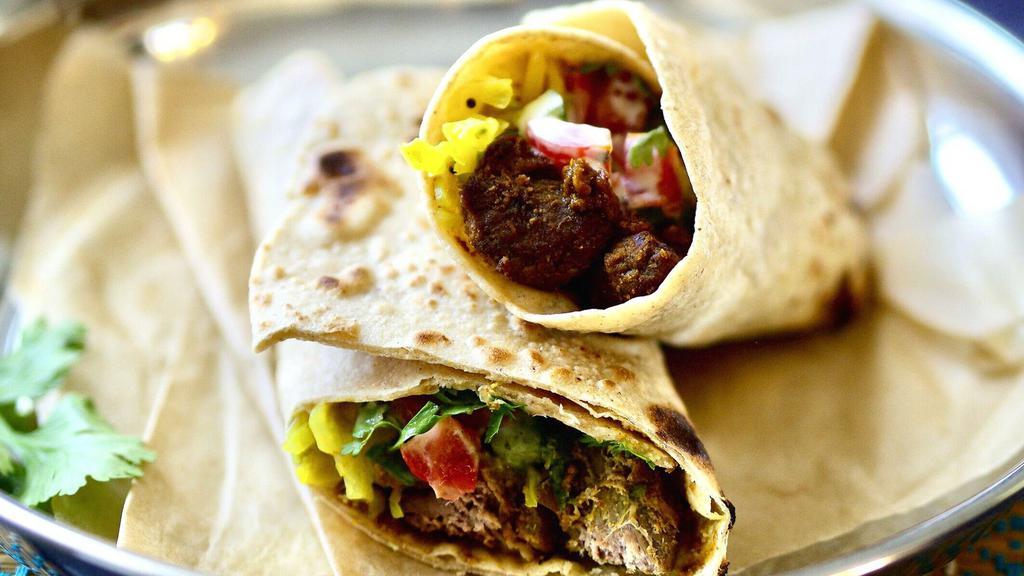 Lamb Curry Burrito · Rich lamb curry with basmati rice, diced cucumber and tomato, shredded cabbage, and mint chutney in a naan wrap.