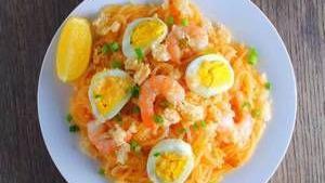 Pancit Palabok · Rice noodles with shrimp and garlic, gravy, topped with a sliced boiled egg, ground chicharr...