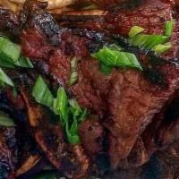 Kal-Bi Ribs · Grilled Thin Cut Beef Short Ribs in Korean Marinade. Served with Rice and Choice of Mac Sala...