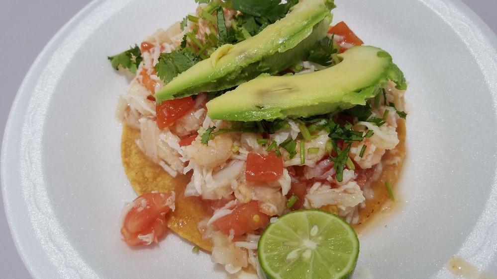 Ceviche Tostada · Crab, fish, and shrimp, topped with cilantro and avocado.