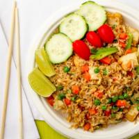 Thai Fried Rice · Fried rice with onions, tomatoes, peas, and carrots topped with cilantro and cucumber.