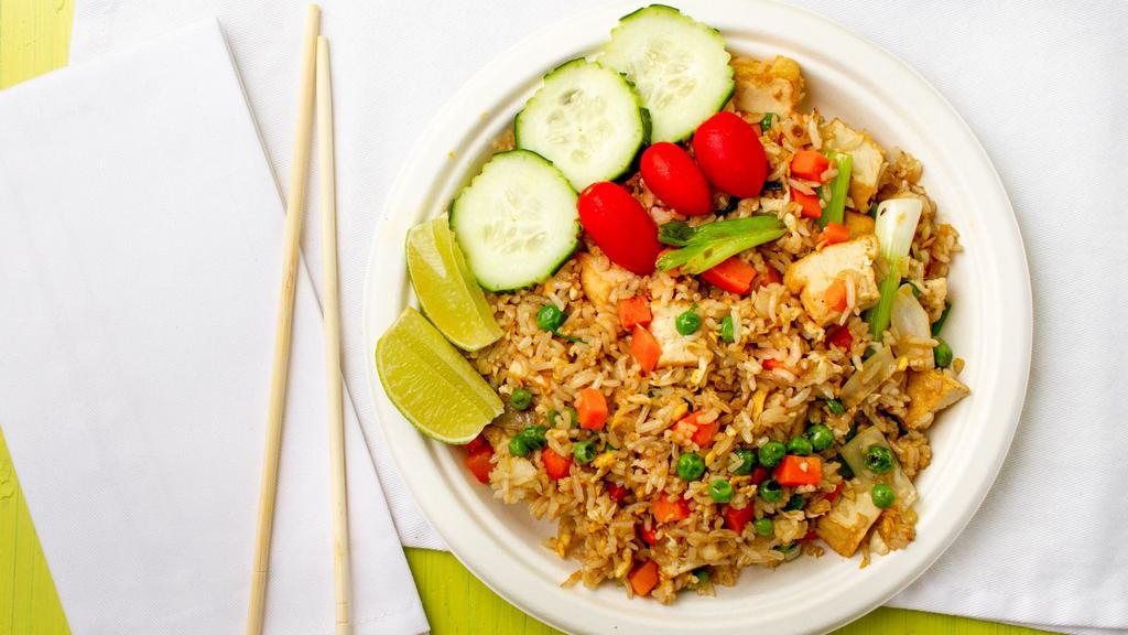 Thai Fried Rice · Fried rice with onions, tomatoes, peas, and carrots topped with cilantro and cucumber.