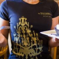 Women'S Chandelier T-Shirt · Black fitted Bella crewneck 100% cotton t-shirt with an off-center gold chandelier imprint o...