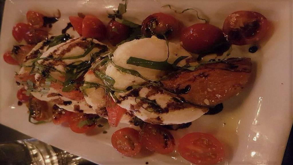 Heirloom Caprese Salad · Fresh house-made Mozzarella cheese, heirloom tomatoes and fresh basil chiffonade drizzled with a thick balsamic reduction, local olive, and basil oils.