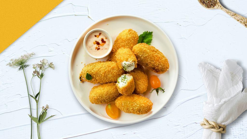 Caliente Poppers · Cream cheese stuffed jalapeno poppers, dipped in spicy breading, and fried until golden crisp.