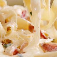 Fettuccine Carbonara · Fettuccini sauteed with bacon, mushrooms, tomatoes, green onions in alfredo sauce, then topp...