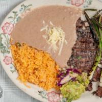 Carne Asada · Skirt steak buttered and flame broiled, served with rice, beans, guacamole and tortillas.