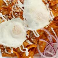 Chilaquiles · Fried corn tortillas, red sauce, two over easy eggs, topped with sour cream and queso fresco...