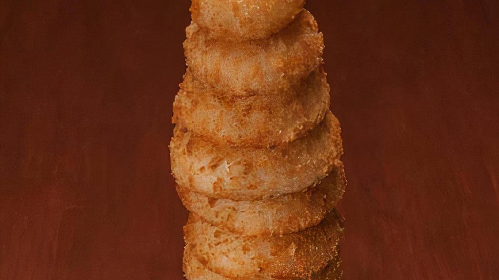 Towering Onion Rings · A golden monument to goodness, thirteen rings tall. Served with campfire sauce and ranch dressing.