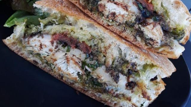 Charmingly Pesto · Roasted chicken, melted mozzarella, basil pesto, roast tomatoes, balsamic reduction, toasted ciabatta. Add chips for an additional charge.