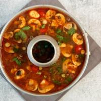 Tom Yum  Koong · A medium and sour soup with mushrooms, lime juice, Kaffir leaves, lemongrass, tomato and spi...