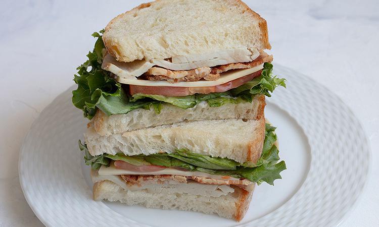 Turkey Club · Turkey, bacon, Swiss, tomato, and lettuce on rustic white bread. Please no substitutions or modifications.  (mayonnaise now comes on the side)