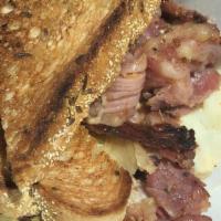 The Reuben · Our pastrami or corned beef, tangy kraut, provolone, thousand island and pickles on grilled ...