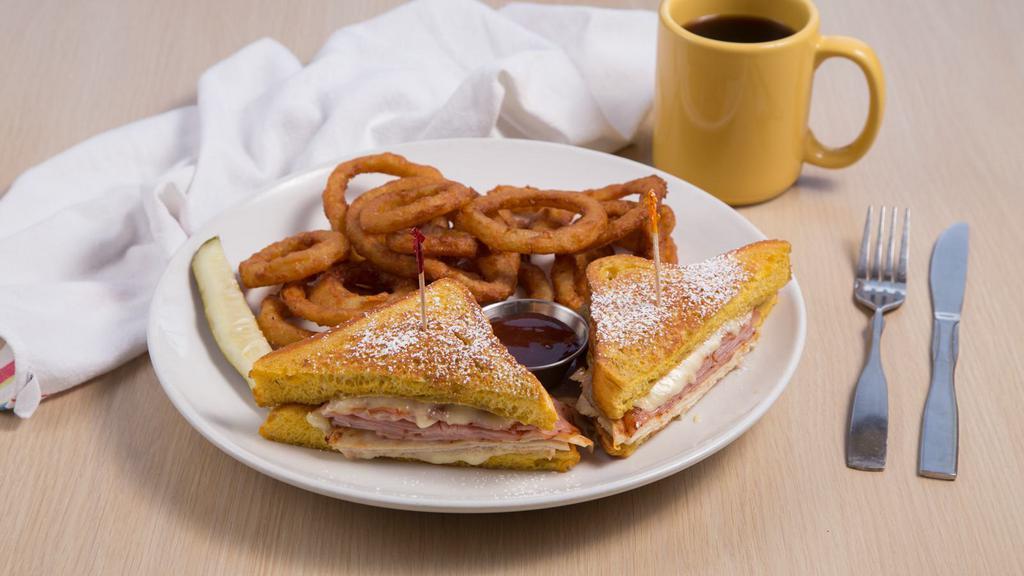 Monte Cristo Sandwich* · Thick slices of homemade brioche bread dipped in egg batter pan fried to golden brown, with thinly sliced ham, crisp bacon, and Swiss cheese.