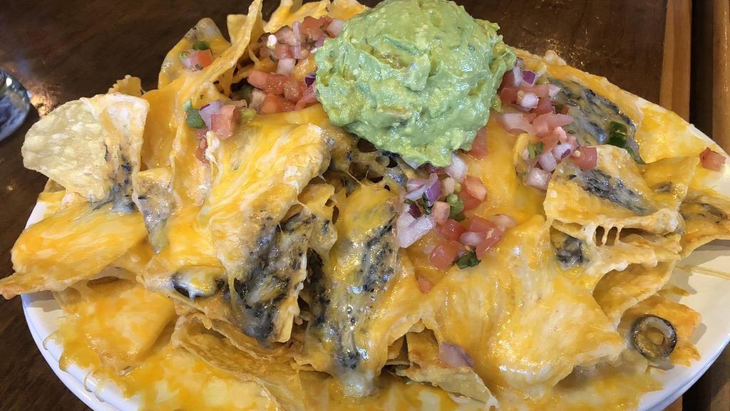 Personal Nacho · Personal sized nacho with our homemade corn chips, pinto beans, cheese blend, olives, pico de gallo, jalapenos, sour cream, and guacamole. Add brisket, chicken, or ground beef for 3.50