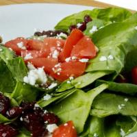 Spinach Salad · Fresh baby spinach topped with fresh tomato, walnuts, cranberry raisins, and feta, served wi...
