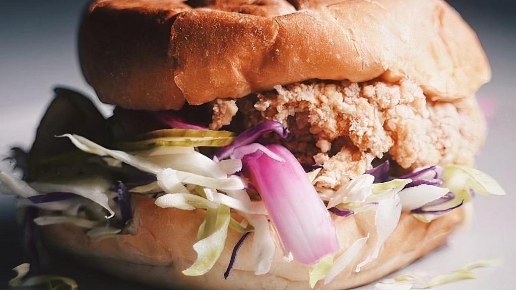 Fried Chicken Sandwich* · Contains gluten. 
A giant 6 oz slab of chicken thigh breaded with a sweet potato starch and rice flour batter, fried, and sandwiched between slaw, pickled cucumbers, pickled onions, our homemade garlic aioli sauce*, and a pub bun. 
Contains: Eggs, Soy, Wheat