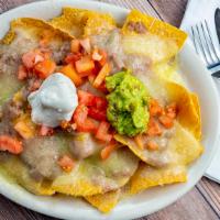 Nachos Supreme · Corn chips, topped w/beans, cheese, ground beef, guacamole, sour cream and diced jalapenos.