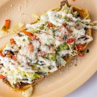 Hurachon · Fried masa oval layered with beans, choice of protein, lettuce, sour cream, queso fresco, an...