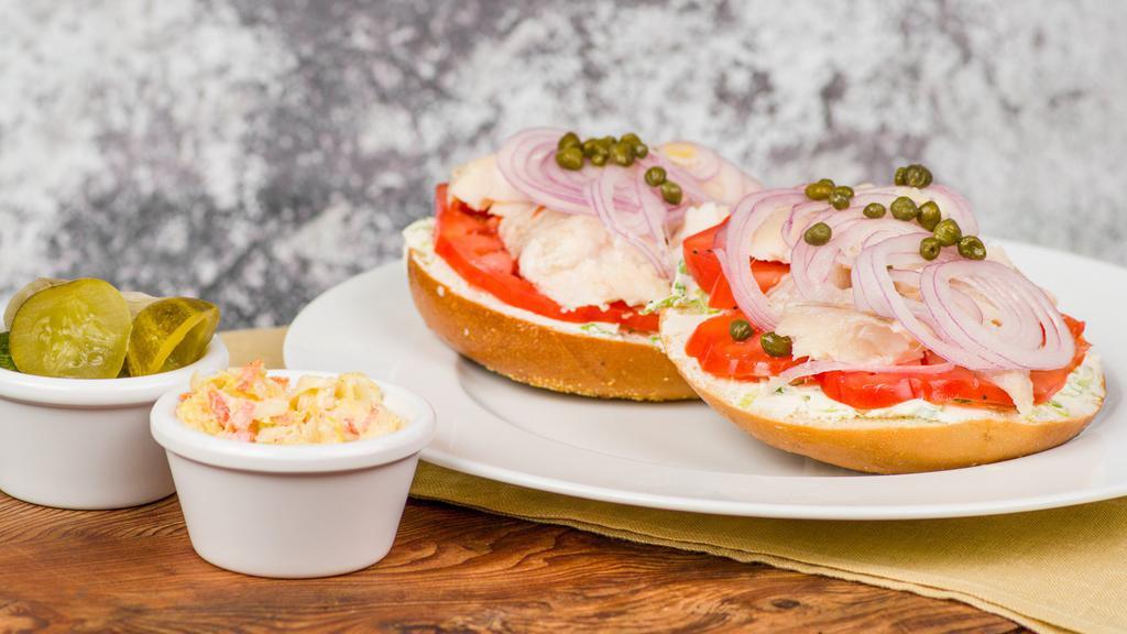Bagel With Whitefish Salad & Schmear · Whitefish salad on a bagel of your choice served open-faced with capers, heirloom tomatoes, red onion, and choice of scallion, plain, or olive schmear.