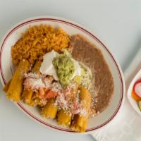 Taquitos Rancheros · Deep fried chicken taquitos with tomato, cheese, rice, beans, sour cream, beans, and lettuce...