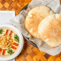 Hummus · A creamy blend of puréed chickpeas with tahini, garlic, lemon juice and olive oil. Served wi...