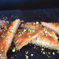 Baklava · Filo dough stuffed with walnut, baked and garnished with honey and pistachio.