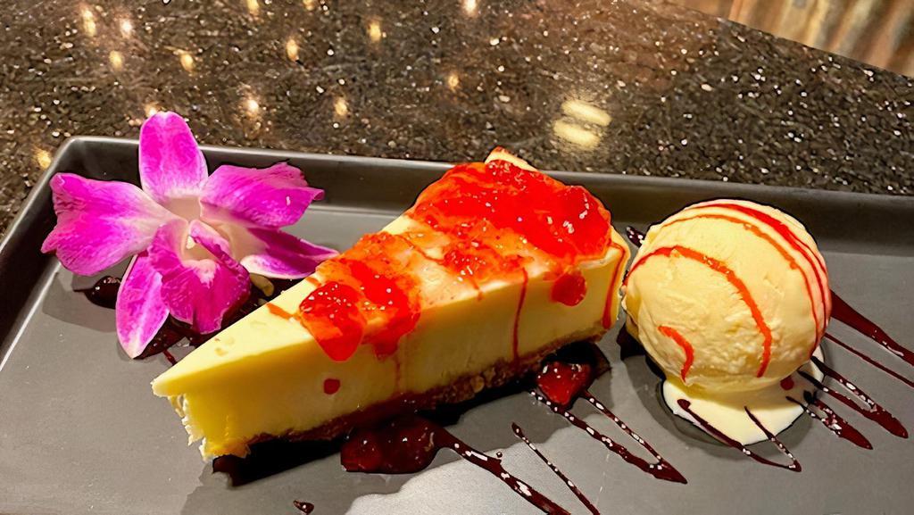 New York Cheesecake With Ice Cream · New York cheesecake with two scoops of vanilla bean ice cream. Topped with strawberry jam and strawberry syrup.
