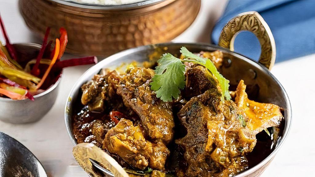 Madras Goat Curry · (GF). Southern spiced goat (bone-in) curry with mustard, fenugreek, curry leaves and sambhar spices