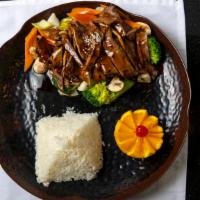 Whiskey Beef · Grilled beef strips marinated in whiskey on a sizzling plate, served with veggies.