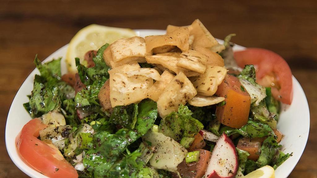 Fattoush فتوش · Lettuce, tomatoes, cucumber, radish, green onions and mint, seasoned with olive oil and lemon juice. Topped with toasted pita bread.