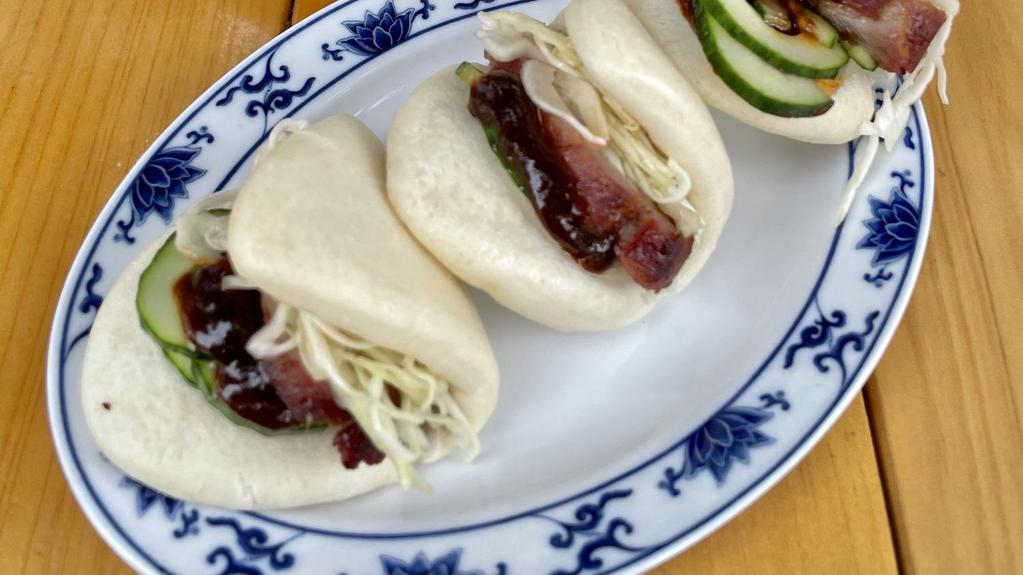 Char Siu Buns · Three (3) folded steamed buns filled with char siu (BBQ pork), pickles, red cabbage, and house-made apple-hoisin sauce.