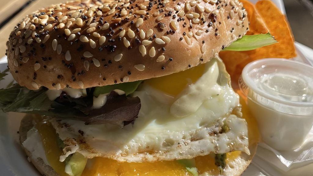 Avocado Dream · Avocado, cream cheese, cheddar, sunny side up, spring mix, avocado ranch on everything bagel + chips.