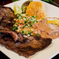 Carne Asada · Grilled steak with beans topped with cotija cheese, rice, pico de gallo and choice  corn or ...